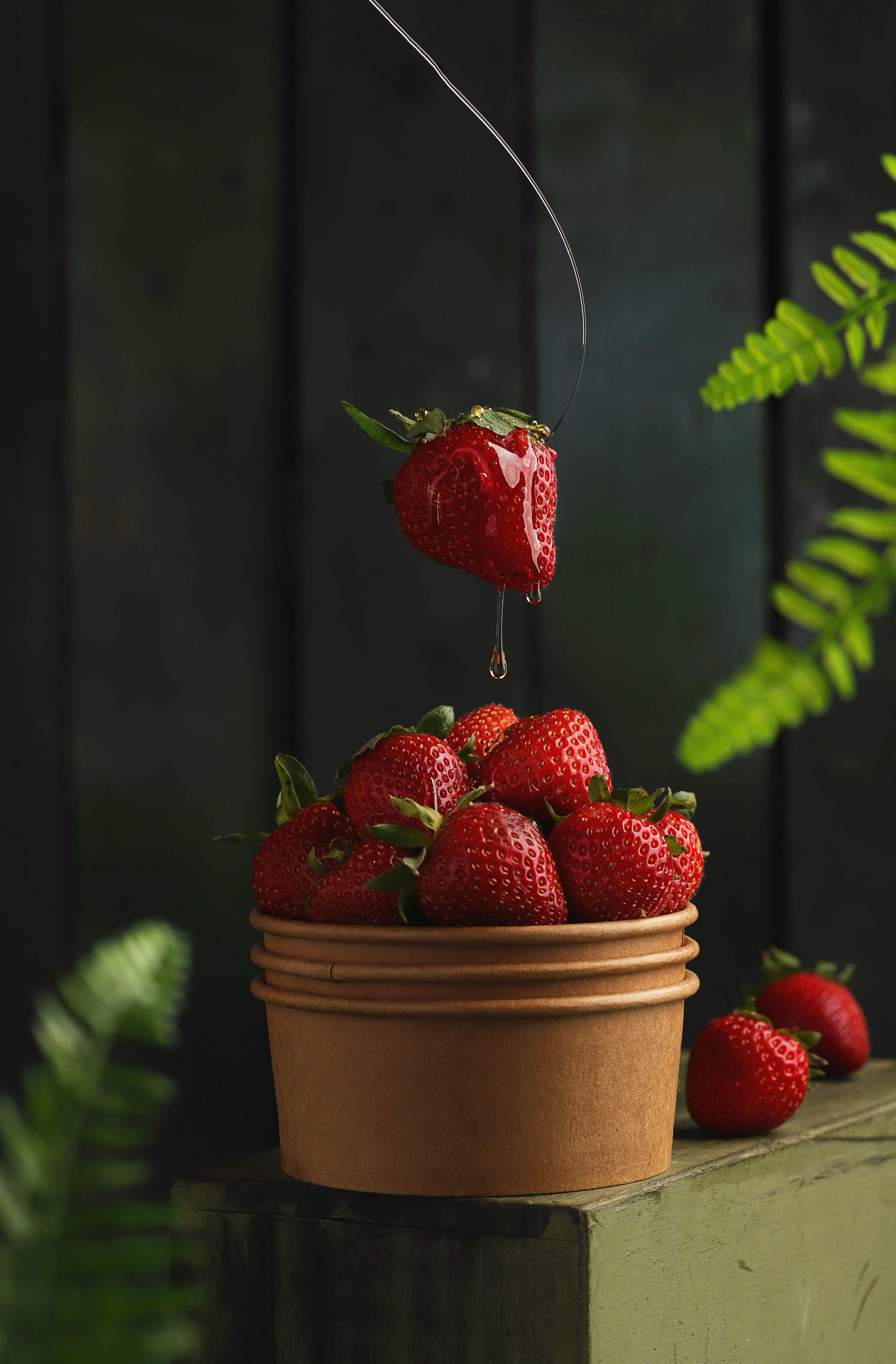 red strawberries on brown round container